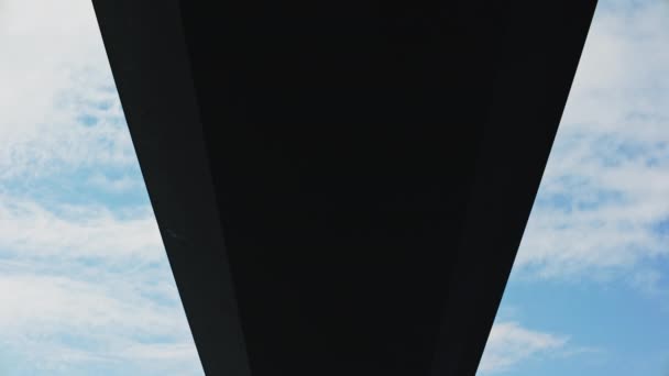 下方に移動する傾斜ショット 下の穏やかな青い水でグレートベルト橋のコンクリートの壮大さをキャプチャ — ストック動画