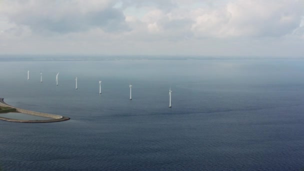 右から左に移動するパンショット風力タービンとデンマークの穏やかな海に位置するグレートベルト橋 — ストック動画