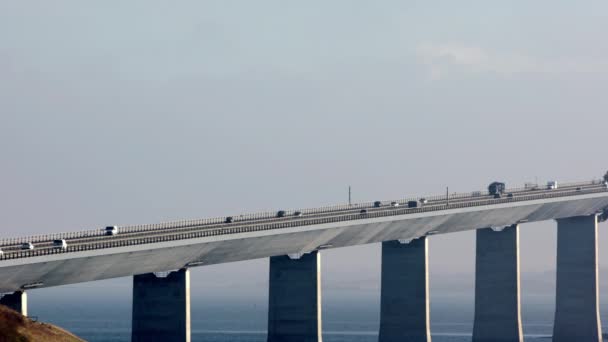 パンは デンマークの広大なベルト橋を横断するように車のリズミックな動きをキャプチャする左から右に移動ショット — ストック動画