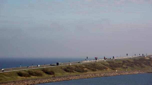 パンはデンマークの象徴的なグレートベルト橋を横断するように車のリズミックな動きをキャプチャする右から左に移動ショット — ストック動画