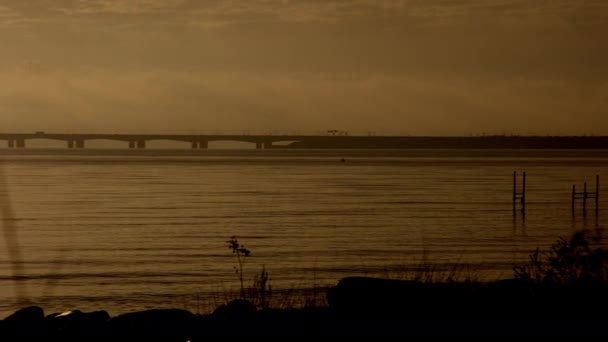 パンはデンマークの日没の間にグレートベルト橋を示す右から左に移動するショット — ストック動画