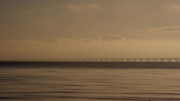 左から右に移動するパンショットは デンマークの夕日中にグレートベルト橋の息をのむような景色を撮影します — ストック動画