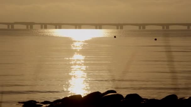 在丹麦宁静的水面上 一道静态的镜头捕捉了大贝尔特桥 同时还闪烁着阳光的光芒 — 图库视频影像