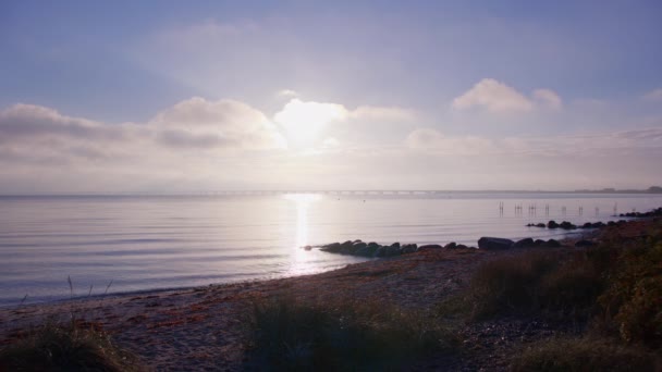デンマークの海岸の静かな背景に対するグレートベルト橋の息をのむような景色を撮影した静かなショット — ストック動画