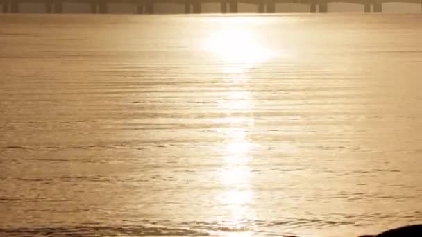 丹麦落日时分 一个倾斜的镜头向上移动 捕捉到平静的海水和大贝尔特桥的轮廓 — 图库视频影像