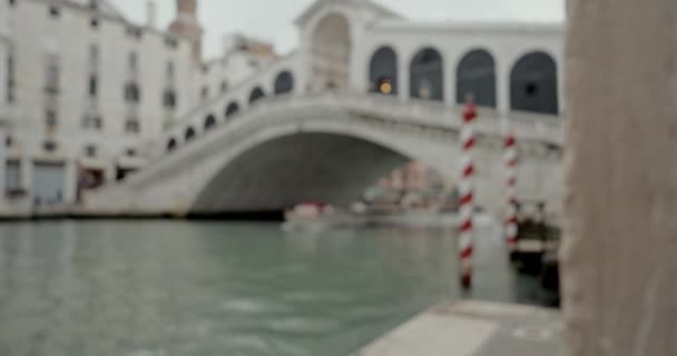 象徴的なリアルト橋と通過ボートは優雅に焦点を当て ヴェネツィアの歴史的な運河に沿って視覚的に見事でダイナミックなシーンを作成します — ストック動画