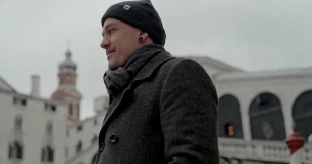 一个身穿黑色燕尾服和夹克的男人转过头去 欣赏威尼斯标志性的丽亚尔托桥的壮丽景色 — 图库视频影像