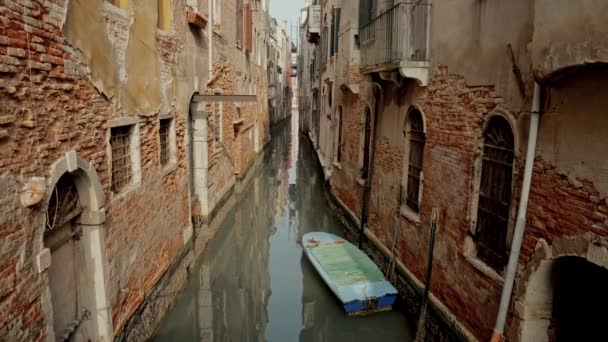 一艘船优雅地停靠在历史性的砖墙中 沿着迷人的威尼斯运河 营造出宁静美丽的景象 — 图库视频影像