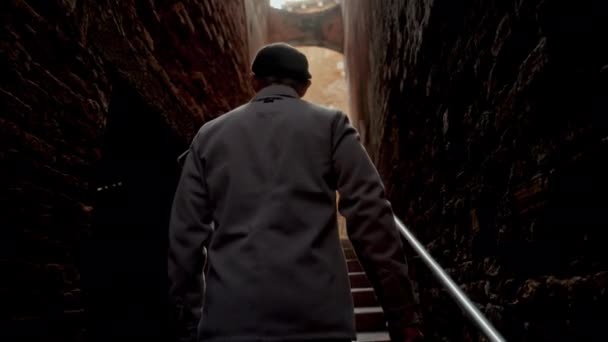 一个男人在黑暗的小巷里走楼梯 然后爬上威尼斯运河上的一座小桥 停下来欣赏风景的背景图片 — 图库视频影像