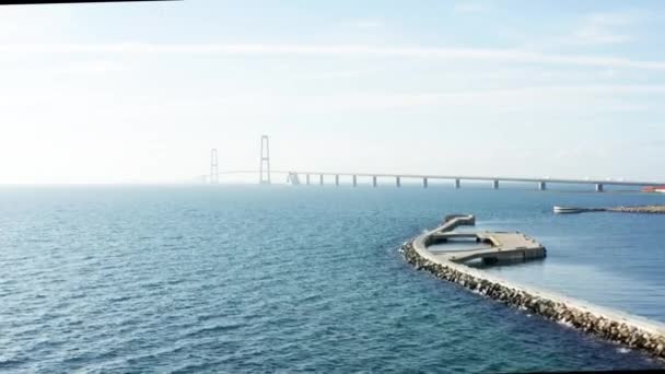 象徴的なグレートベルト橋で広大な青い海を捉えたドローンが徐々に危険な地平線に消えていく — ストック動画