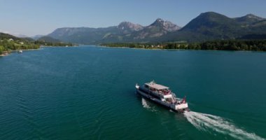 Avusturya dağlarının insansız hava aracı görüntüleri ve sakin bir göl, el değmemiş sularda seyreden bir tekneyi gösteriyor.