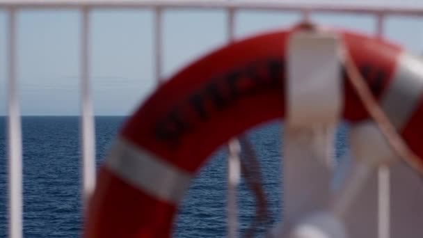 広大な青い海の背景に設定されたフェリーに焦点を当てていない生命のブイ — ストック動画