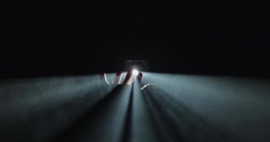 Karanlığın ortasında tek ve parlak bir ışığa karşı zarifçe siluetlenmiş bir el.