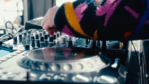 다채로운 패턴의 검은색 스웨터로 장식된 Dj의 숙련된 클로즈업 믹서와 턴테이블에 — 비디오
