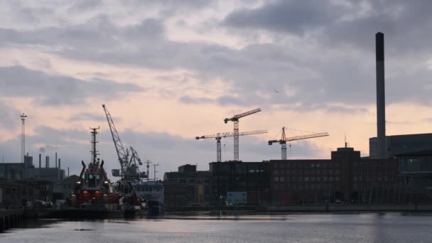 Molniga Skyar Skymtar Över Byggkranar Och Byggnader Århus Hamn Solnedgången — Stockvideo