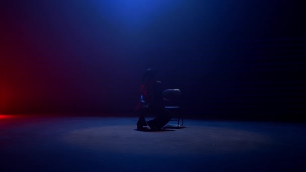 完全な静的なショットは 赤と青のライトで強調された薄暗い部屋で女性の膝スライドダンスをキャプチャします — ストック動画