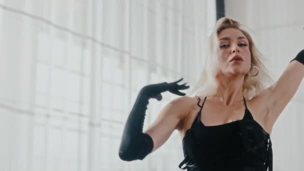 ミニマリストのホワイトスタジオで優雅に踊る女性を撮影する中型のハンドヘルドショット — ストック動画