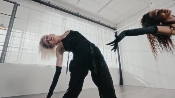직업적인 스튜디오에서 그들의 미끄러지는 움직임을 보여주는 검은색 의상에서 여자를 — 비디오