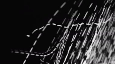 Hızlı hareket eden beyaz ışık bir hareket patlaması yakalar ve karanlık bir arkaplanda parlak izler yaratır.