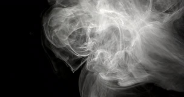 白烟在空中扩散的明亮的白烟的特写镜头 在被黑色背景驱散之前先旋转 — 图库视频影像