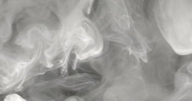 Büyüleyici duman girdapları zarif bir şekilde karanlıkta dans ediyor büyüleyici ve gizemli bir ortam yaratıyor.