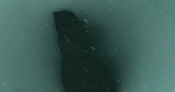 大雪の間に湖の表面に氷に囲まれた凍結していない水のパッチのオーバーヘッドショット — ストック動画