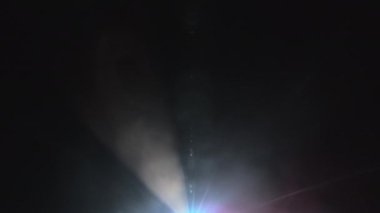 Projektör ışığı karanlığın ortasında karmaşık bir dans yapıyor.