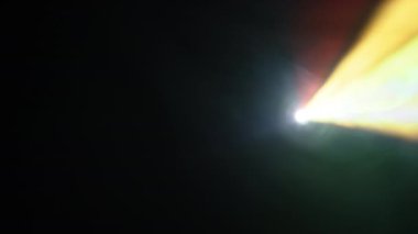 Parlak ışınlar projektörden yayılır, sahneyi dinamik enerji ve büyüleyici renklerle boyarlar