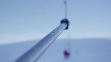Kayakçıları ve snowboardcuları güvenli bir şekilde dağa taşımaya hazır çelik kablolara bağlı bir kayak tüpünün yakın plan çekimi.