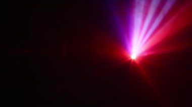 Bir projektörden çıkan pembe ve kırmızı ışıkların büyüleyici birleşimi büyüleyici ve canlı bir görüntü sergiliyor.