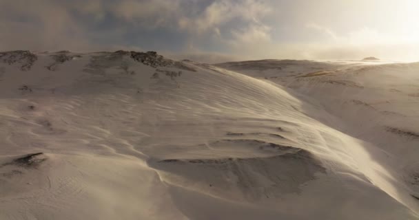 日没の雪山頂を流れる強い風のように自然の息を呑む力を捉えたドローン — ストック動画
