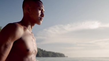 Bir Muay Thai savaşçısı geleneksel Wai Kru ayinini plajda gerçekleştirir.