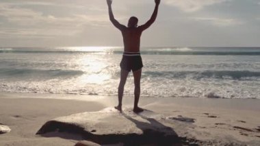 Bir Muay Thai dövüşçüsü titizlikle ve disiplinle yoğun bir eğitime hazırlanarak esneme hareketleri yapar.