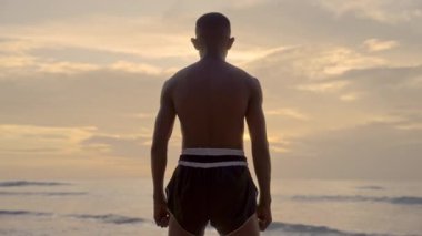 Gün batımında dalgalara karşı kararlı bir boksör.