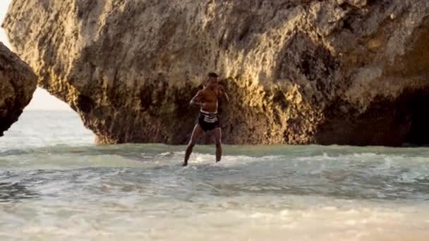 一名穆阿泰战士在海岸岩石上磨练他的冲撞和肘部技术 免版税图库视频片段
