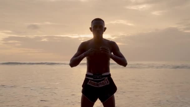 一名穆艾泰籍拳击手参加了一个独特的仪式 在日落时分海滩波浪的节奏碰撞中 他与自己扭打着指节 — 图库视频影像