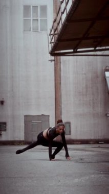 Portre oryantasyonunda tam bir poz. Zarif çağdaş dans yeteneklerini sokak ortasında sergileyen bir kadın.