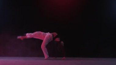 Bir stüdyo ortamında genç bir kadının zarif dans performansının büyüleyici sanatını tam bir çekim. Dönüyor ve zahmetsiz bir zarafet ve akışkanlıkla hareket ediyor.