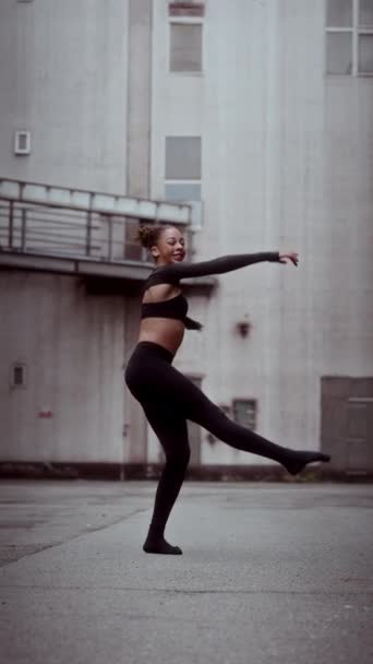 若い女性は 現代のジャズダンスのルーチンの一部としてゆっくりとした動きでスピンします ポートレートオリエンテーションビューでパフォーマンスをキャプチャ — ストック動画