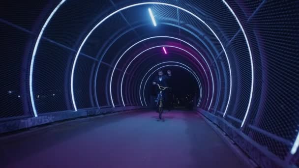 Skicklig Bmx Ryttare Visar Imponerande Manuella Trick Ljuset Kedjelänkstunnel Natten — Stockvideo
