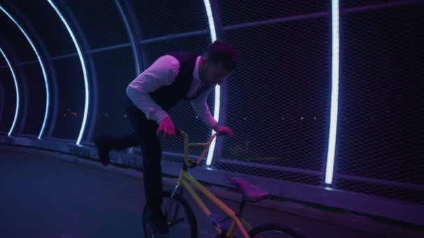 Отслеживающий Снимок Велосипедиста Выполняющего Трюк Рычагом Кишечника Пешеходном Мосту Неоновыми Стоковое Видео