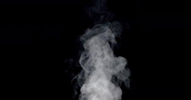 Siyah arka plana doğru yavaşça yükselen kalın beyaz duman havayı dolduruyor. Parlak ışık dumanın şeklini ve hareketini vurgular