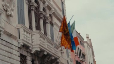 Eski bina gururla duruyor, İtalya, Venedik ve Avrupa Birliği bayraklarıyla süslenmiş.