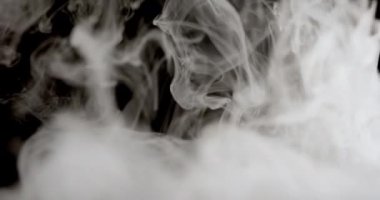 Yukarıdan bir duman bulutu yükseliyor ve bir yüzeye iniyor. Duman yoğundur ve dalgalanır. Karanlık zemine doğru yayıldıkça karmaşık girdaplar ve desenler oluşturur.