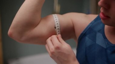 Banyo içinde pazılarını dikkatlice ölçen bir adamı yakalayan ve ilerlemesini kararlılıkla izleyen bir yakın çekim.