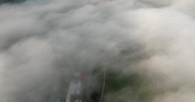 Eğik çekim, sisli bir kasabadan uzak dağların ihtişamına geçiş anını yakalar. Huzurlu bir güzellik ve gizem hissi uyandırır.