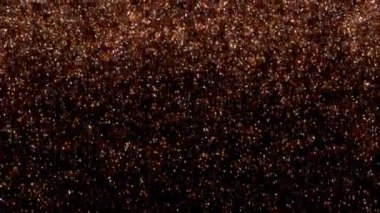 Küçük, ışıldayan turuncu ve sarı parçacıklar, bir yıldız alanına benzerler, karanlık bir arka plana karşı sıcak ve parıltılı bir etki yaratır.