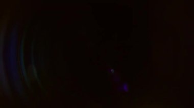 Renkli ve parlak mercek parlamaları saat yönünde döner. Bir yay şeklinde dizilmişler ve koyu arkaplan, alevlerle yüksek bir kontrast oluşturuyor.