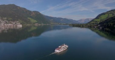 Sakin sulara yansıyan dağlarla dolu güzel bir göl gezisi.