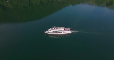 Avusturya 'daki bir dağ gölünde tekne gezisinin tadını çıkaran tatilciler.